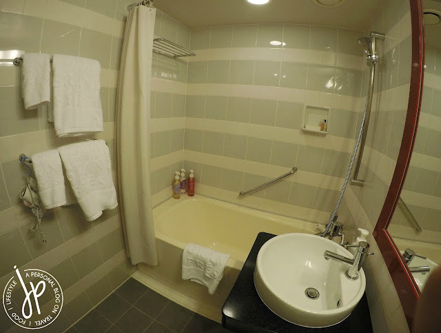 hotel bathroom with toilet, sink, shower, and bathtub