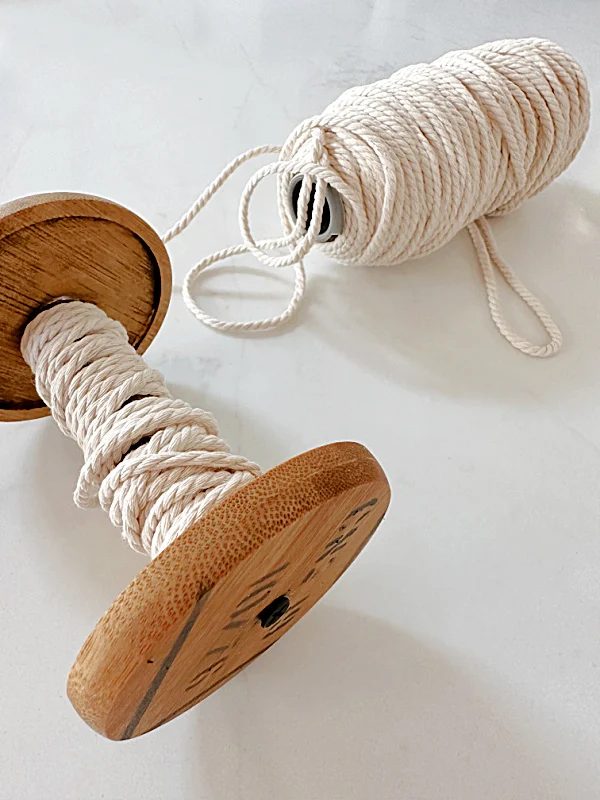 cotton twine wrapping around stenciled wooden spool