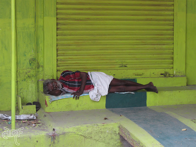 man sleeping in front of his shop