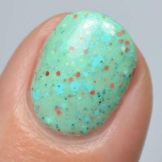 minty nail polish with orange glitter