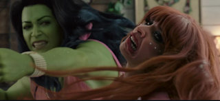 She-Hulk taking a southpaw swing at Titania, breaking her veneers. Titania is a tall woman with dyed red hair and a pained look on her face due to the aformentioned broken teeth.