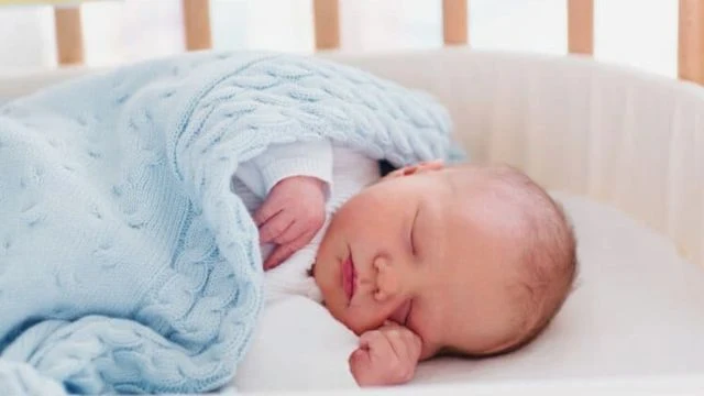Bebê recém nascido dormindo em um berço