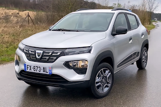 Une Dacia Spring grise en stationnement