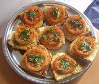 Tostadas untadas de aceite con tomate y pasta de anchoas y ajo