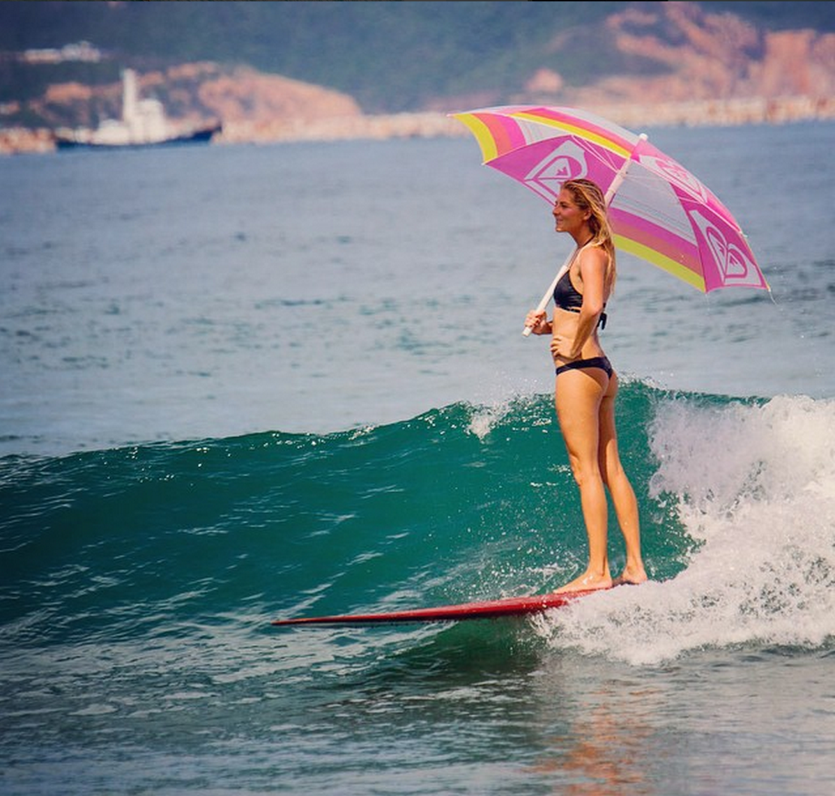 Stephanie Gilmore surfing with umbrella