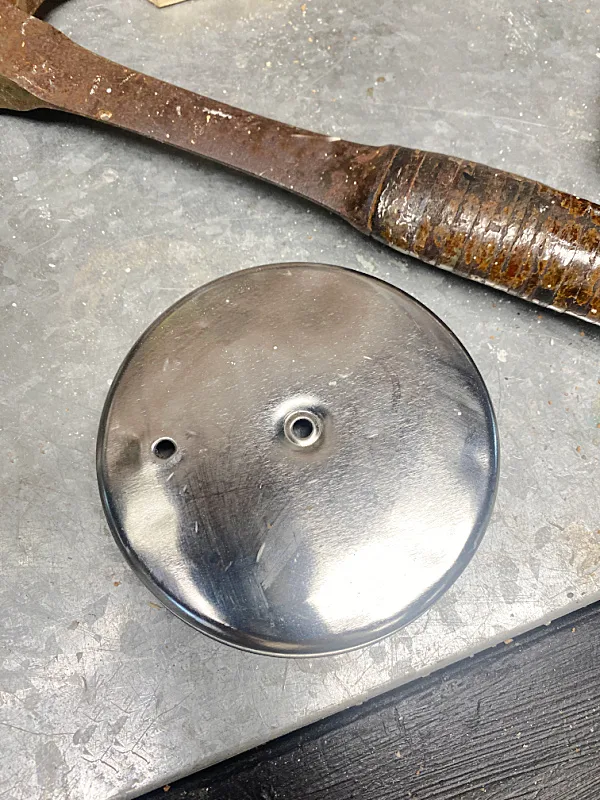 top of can with holes and a hammer