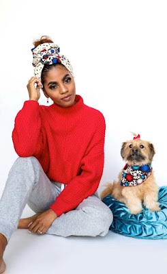 African print dog bandana on a cute little dog, sitting next to a young Black woman with a matching hair wrap