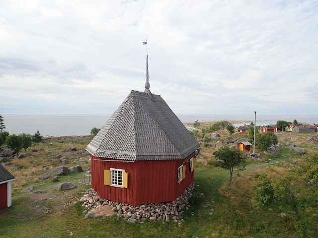 Vanha puukirkko ja kalastajamökkejä saaressa