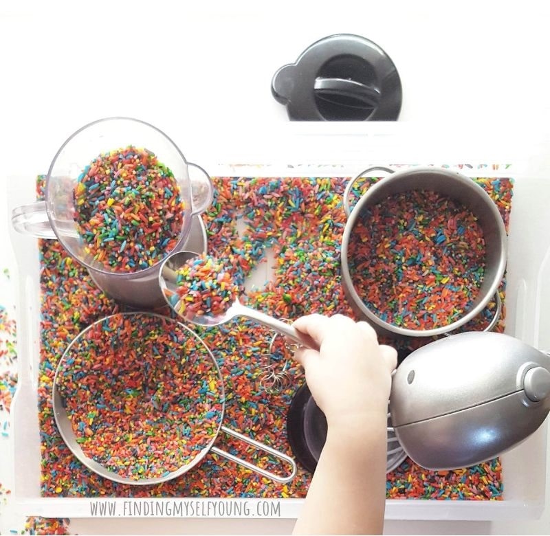 rainbow rice sensory bin with pots and pans