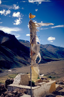 Prayer flag above the monastery (Gompa) of Tanze, in the Kurgiakh valley. The wind is believed to propagate the prayers printed on tissue – Moumine (CC-by-SA-3.0)