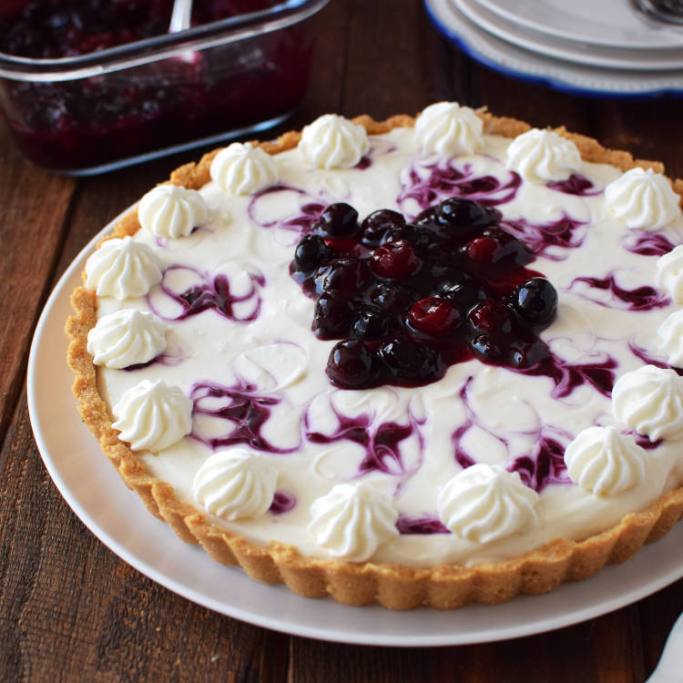 Receta para preparar tarta cremosa con salsa de arándanos