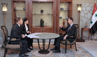 Syrian President Bashar Al Assad (R) speaks during a live interview in Damascus, Syria 21 August 2011.