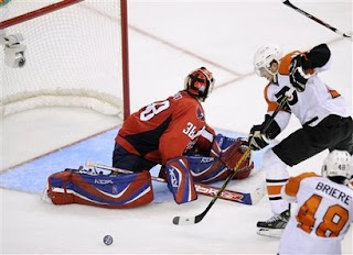 Philadelphia Flyers' Joffrey Lupul, right, works his way around Washington Capitals goalie Cristobal Huet (38), of France, en route to the game-winning goal during overtime of Game 7 of an NHL hockey playoff series Tuesday, April 22, 2008, in Washington. The Flyers won 3-2 to take the series.<br />(AP Photo/Nick Wass)