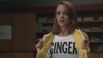 Emma revealing a shirt that says GINGER on it