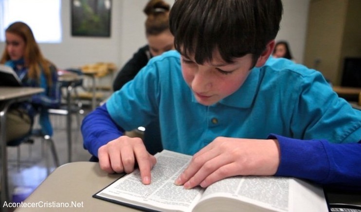 Alumno estudiando Biblia en escuela