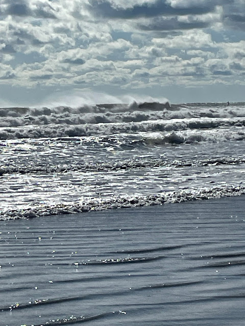 I am in the water probably ankle deep. The waves are much closer to me now and are pretty rough, coming in violently one right on top of another. There are no boats, people, birds, anything in the picture. It is just an angry sea and the sunny sky.