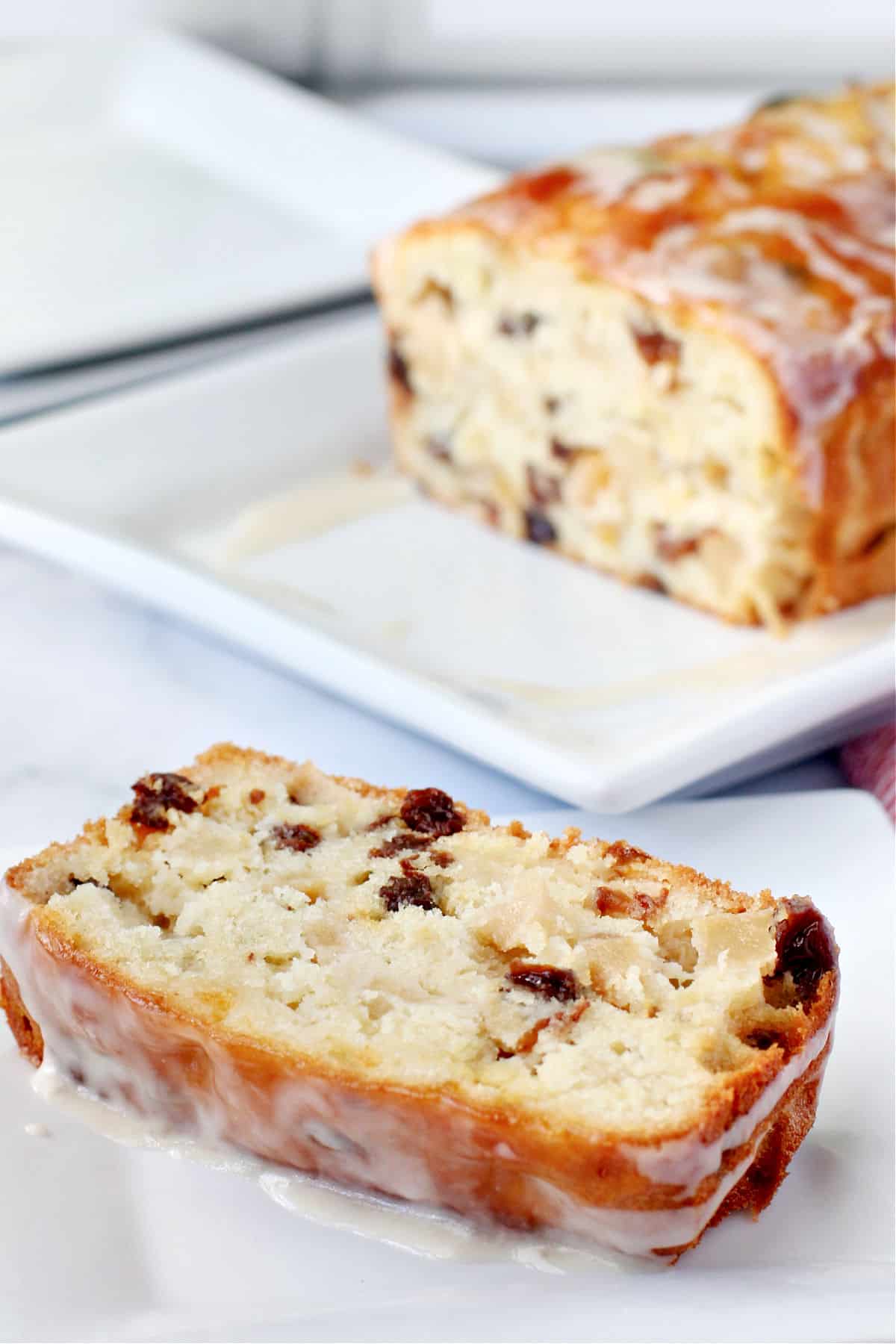 Classic French Apple Cake slice on a white plate with glaze.