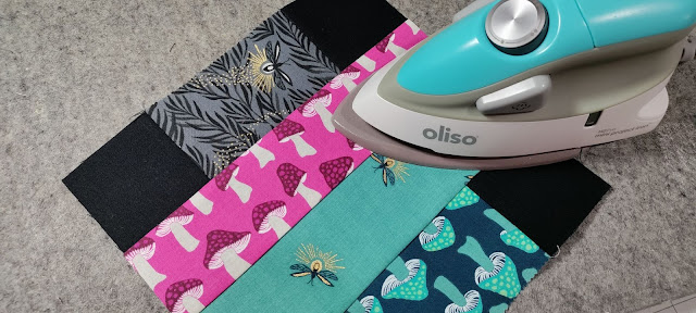 Using a mini Oliso iron and wool pressing mat to press quilt blocks