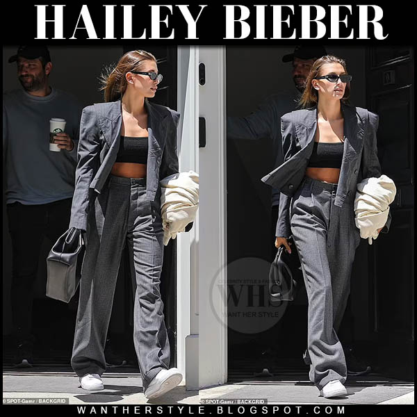 Hailey Bieber in grey blazer, grey trousers and white sneakers