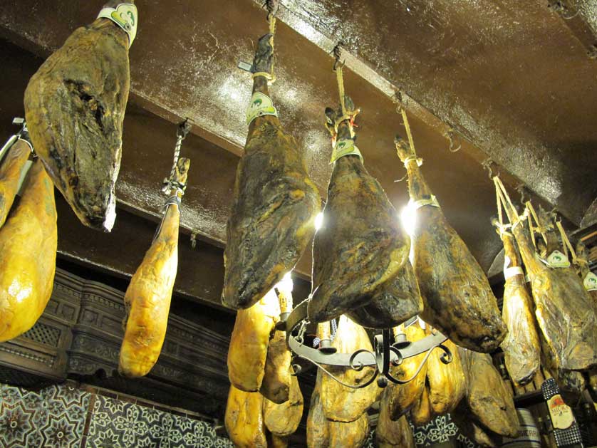 Smoked hams hanging from the ceiling.