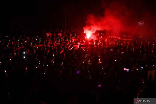 Sejumlah suporter sepak bola menyalakan lilin dan 'red flare' saat mengikuti doa bersama di kawasan Stadion Wilis Kota Madiun, Jawa Timur, Selasa (4/10/2022). Ribuan suporter sepak bola dari Madiun dan sekitarnya menggelar doa bersama untuk para korban tragedi di Stadion Kanjuruhan, Malang. ANTARA FOTO/Siswowidodo/tom (BORNEOJAKATA/ANTARA/SISWOWIDODO)
