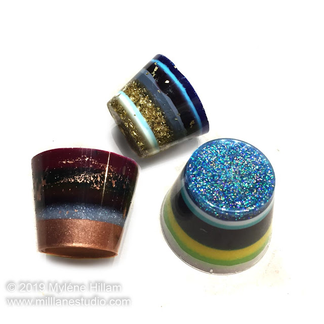 Three 1oz cups filled with multicoloured stripes of resin