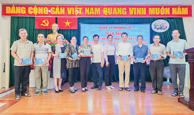 Lãnh đạo Phường 19 trao tặng danh bạ điện thoại  Phường 19 cho các chi bộ, khu phố. (Ảnh: H. Thanh)