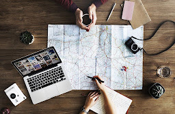 An ariel view of two people carefully planning on a map