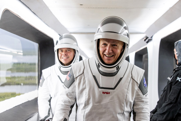 Demo-2 astronauts Doug Hurley and Bob Behnken walk down the Crew Access Arm towards the Crew Dragon vehicle (not visible) for flight at Launch Complex 39A...on May 27, 2020.