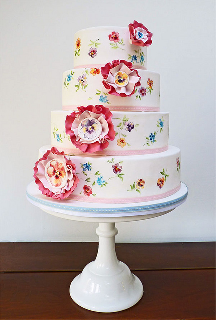 Four tier round wedding cake with colorful hand painted daisies and 