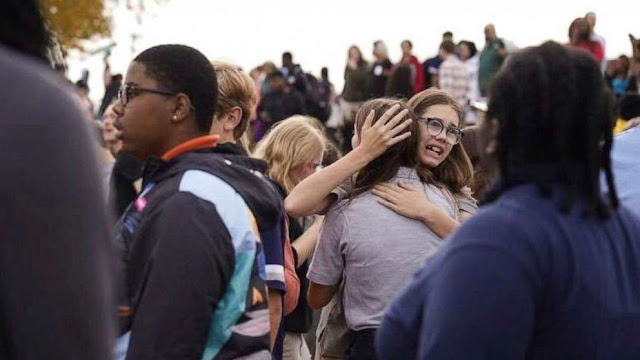 People gather outside after a shooting at Central Visual and Performing Arts high school in St. Louis, on Oct. 24, 2022.