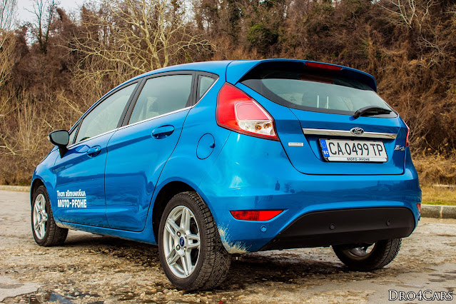 2014 Ford Fiesta - rear vide in 3/4. There‘s a chrome line that underlines the blue Ford oval on the 5th door of the 2014 Ford Fiesta