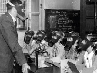 A class of children and their teacher wearing gas masks