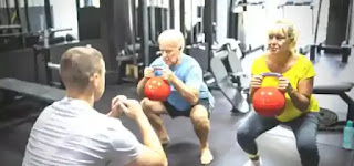 a senior couple performing dumbbell sumo squat
