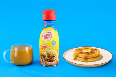 A bottle of Coffee Mate Eggo Waffles with Maple Syrup Flavored Creamer next to a cup of coffee and plate of waffles.