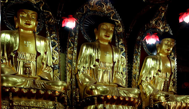 Three Buddha statues with swastikas on their chests, Donglin Temple.