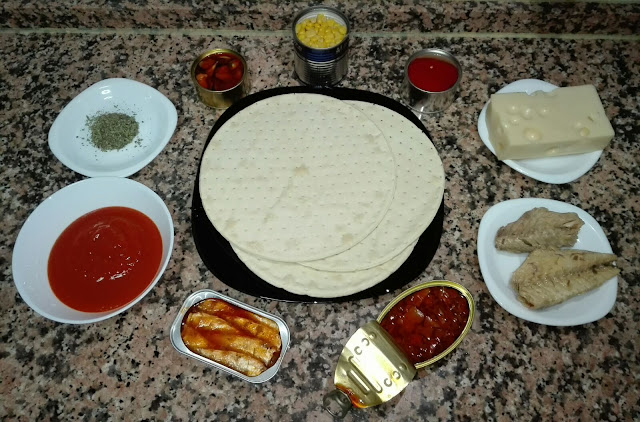 foto en la que vemos un conjunto de alimentos para hacer pizza con una base congelada