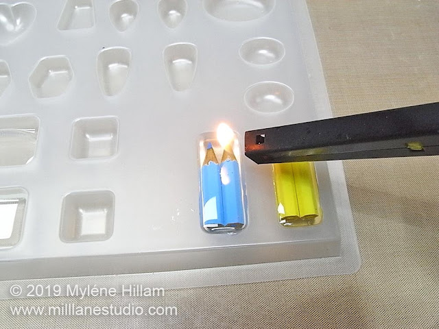 Passing a BBQ lighter across the surface of the resin.