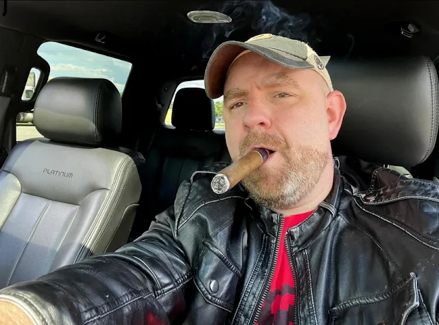 10/12 handsome redneck daddy driving a truck smoking a cigar wearing a black leather jacket over top of red flannel