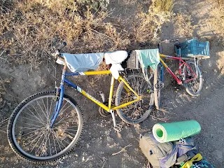 Two bicycles, standing on a rock, clothes are hanging on them for drying