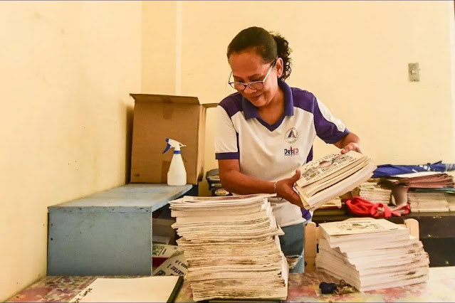 Overwhelmed DepEd teacher doing paperwork