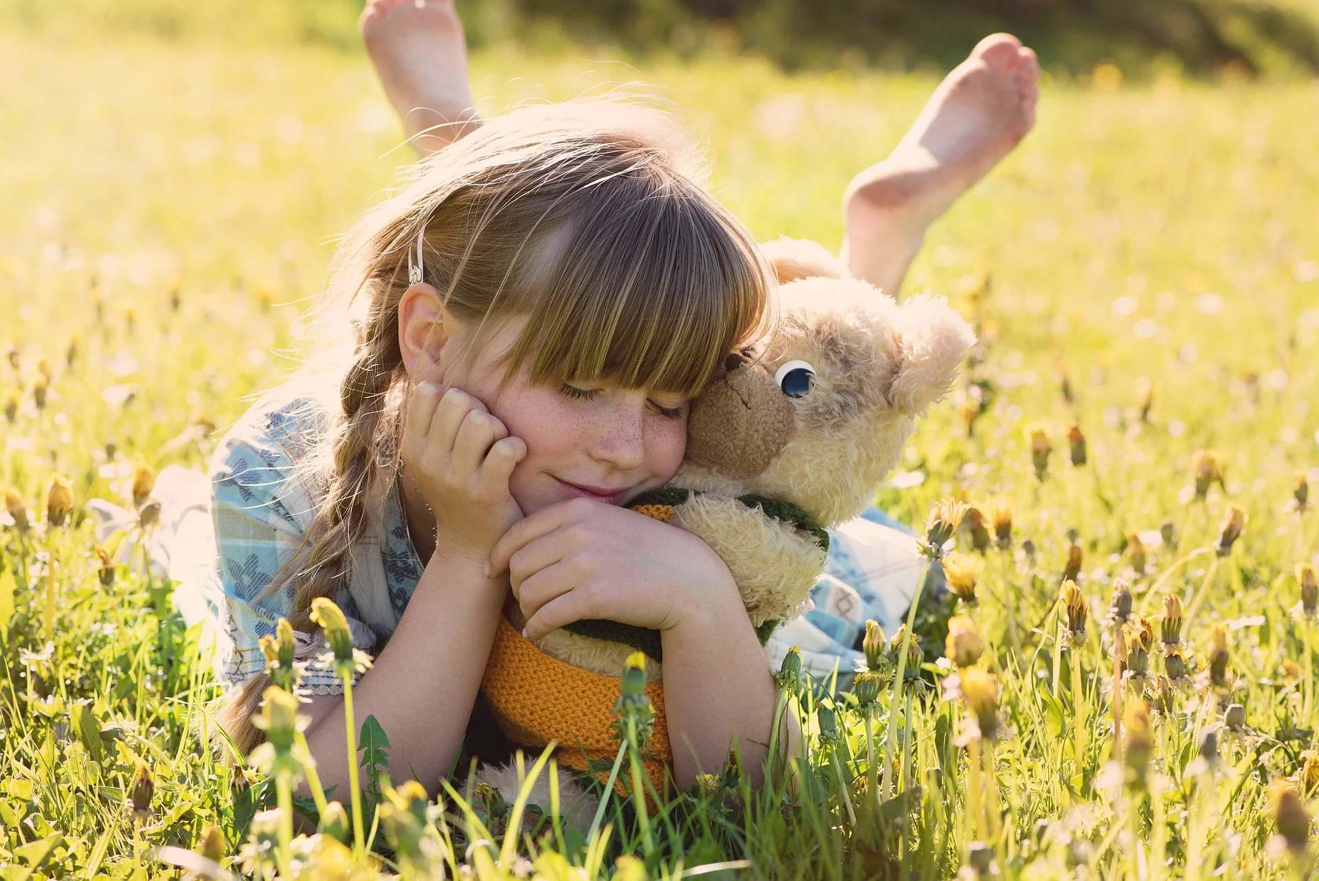 A girl lying in a vibrant flower garden, cuddling her plush bear, depicting emotional well-being, comfort, and tranquility.