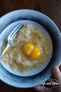Bowl with mashed bananas, two raw eggs and fork
