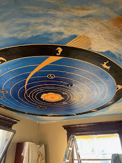 Neal Cronic - Celestial painting with rich blue tones of northern sky and a ring around it featuring indigenous animals on the ceiling of Hotel Montreal in Bellingham. The painting is in the library of this 1890 landmark.