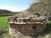 Part posterior de la barraca de Cal Carrano on s'aprecia el voladís de pedres planes i la finestra