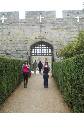 The first day of our Warwick and Cotswolds trip was spent in Warwick, roaming around Warwick Castle and the city of Warwick. The Castle was erected by William the conquerer in 1068 AD. It is built on the banks of the river Avon in the county of Warwickshire.The castle was surrounded by expansive gardens and many Indian peacocks were roaming around freely. One of them was feeling particularly amorous and kept on chasing a peahen with its magnificient wings spread wide. Every few seconds, it would shake the wings so that they shivered in tune with some private song playing its heart. And I could not believe that I was witnessing the legendary peacock dance.The outer wall  and one of the towers of the Warwick Castle. The Castle was fairly intact considering how old it actually is. The ground was lush green and the grey Castle stood out in stark contrast with it.Kelsey and Hannah in front of the tall gates of the castle. Surrounding the castle was a moat that is no longer filled with water.Once you walk into the gates, you find yourself in an open space surrounded by centuries-old walls and towers. When we went there, we found that it was quite crowded with many other coaches visiting the castle at the same time. Roaming amongst them were several employees of the castle who had dressed up in period costumes.Look at this beautiful lady and her maid who's helping her get dressed. The dress itself is lavish and royal. And now to reveal the secret. These aren't actual people. They are statues. Another employee dressed in period costume. Some were friendly while some seemed to plainly hate their jobs. It must be stressful to dress up in the same costume day-after-day and try to interact with visitors.Just a stuffed bear. Hunting must've been a popular sport back then. I'm glad the trends have changed now.Not only were people dressed up, there were some animals as well. Here's a horse with a knight on its back. I'm glad that none of them are real. I was wondering how horses felt about dressing up in such uncomfortable gear. Nobody asked them ever I'm sure.Another horse statue and this one in a much more comfortable attire. Though that metal thing on its face seems extremely restrictive. However, this horsey's tale swished and it occassionally batted its eyelids. So I think this one wasn't so miserable.The main residential and administrative buildings of the castle. On the far left was a Gael (pronounced Jail and means Jail too). I'll take you inside soon.The picture was clicked from the top of the Castle Wall.This is the insides of the Gael and hanging on the top is a Gibbet one of the torture devices used in medieval times for criminals like murderers and sheep stealers. Why sheep stealers though, I cannot imagine. Anyways bodies of ciminals were usually suspended in these after they had been executed to set an example for other criminals. Worse still, sometimes people were gibbetted alive and starved to death in public places. Needless to say, the public were not having it and such practices often backfired against the monarchs.Somewhere on the grounds we found a skeleton trying to escape its grave. Hannah made friends with it and it does look happy as a result. *grin* *wink* *grin* a boathouse behind the castle on the opposite bank of the river Avon. This picture was also clicked from the top of the castle walls.Hope you enjoyed this brief walk inside the castle. Before this we've been to Banbury. Here's a link to that post: A Chance Stop at Banbury. UK, Warwick, Warwick Castle, peacocks, History