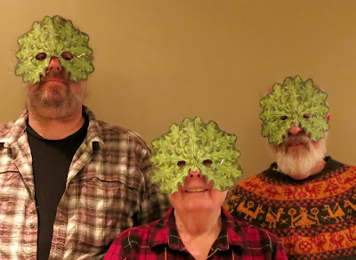 Three people wearing Green Man mask by Judith Hoffman