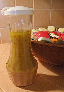 Bottle of Homemade Dressing with Salad in Background