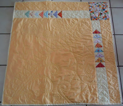 The FMQ curved strip of flying geese crosses the quilt