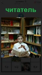 мальчик читатель около книжных полок с раскрытой книгой
